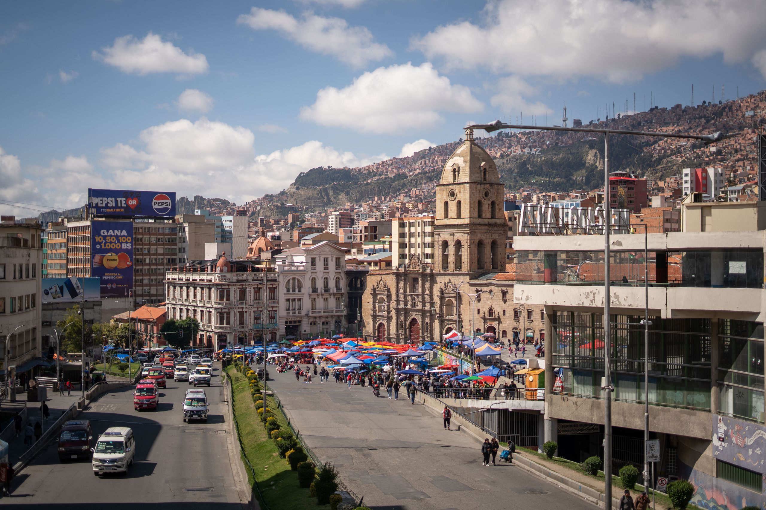 Explore the bustling market in La Paz, Bolivia, with its historic architecture and lively atmosphere.